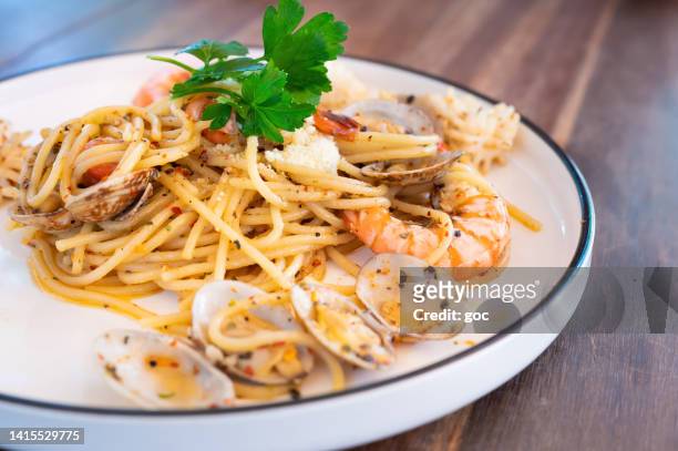 meeresfrüchte-spaghetti mit venusmuscheln, garnelen und tintenfischen - clams cooked stock-fotos und bilder
