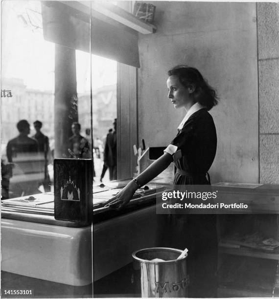 The Italian shop assistant Liliana attending costumers at Motta ice-cream counter. Milan, 1950s