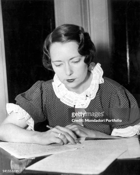 The American writer Margaret Mitchell writing sitting at a table. 1936
