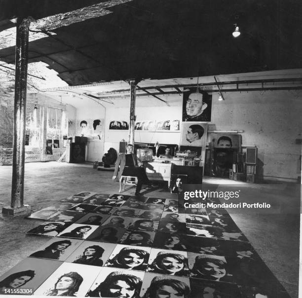 The American artist Andy Warhol sitting in his studio. Some paintings depict Jacqueline Kennedy. New York, 1964