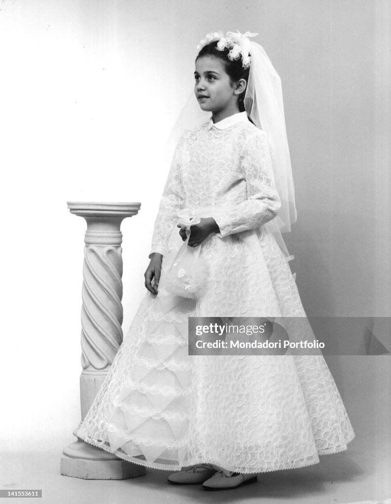 An Italian girl wearing the First Holy Communion dress made of lace ...
