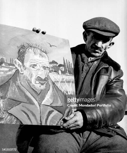 The Italian painter Antonio Ligabue posing with a self-portrait. Reggio Emilia, March 1961