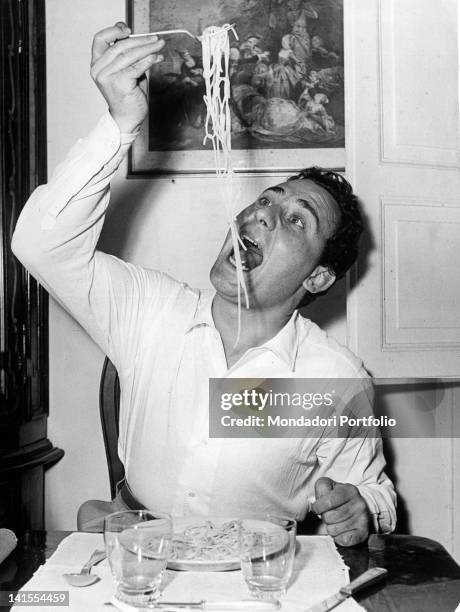 The Italian actor at table eating a plate of spaghetti