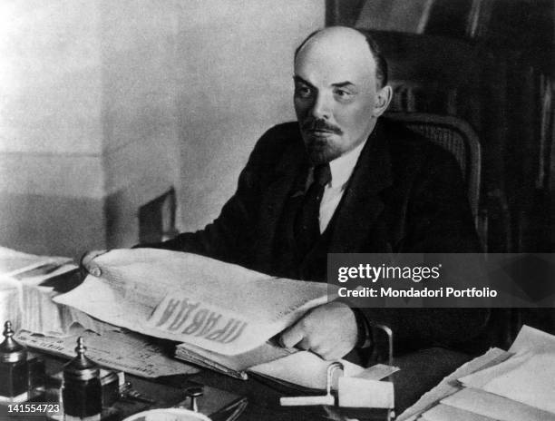 President of the Council of People's Commissars of the USSR Lenin reading a copy of 'Pravda' sitting at his desk. USSR, 1910s