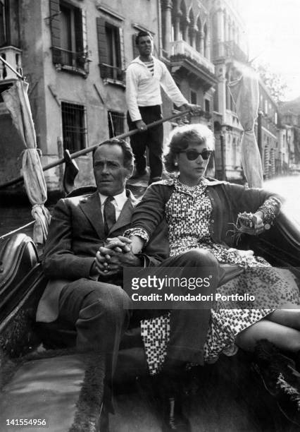 The American actor Henry Fonda and his wife Afdera Franchetti on a gondola on a canal in Venice. Venice, 1957