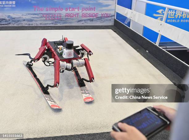 Man controls a skiing robot developed by a team from Shanghai Jiaotong University during 2022 World Robot Conference at Beijing Etrong International...