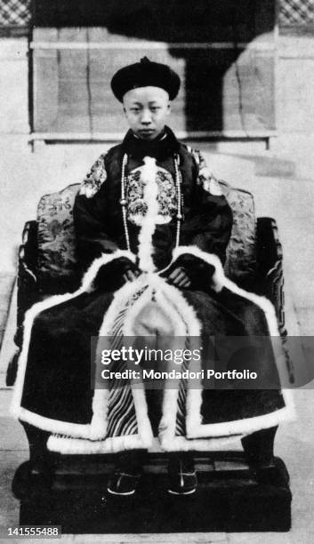 The last emperor of China Pu Yi sitting on the throne at the age of eleven. China, 1917