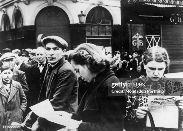 Belgian civilians read bills with the proclamation issued by the German Command after the occupation of the city. Lieges, 13 May 1940