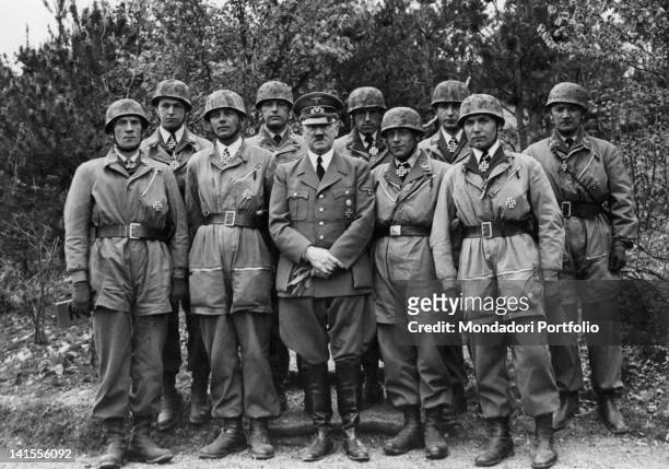 German Chancellor Adolf Hitler posing with a group of paratroopers decorated with the Iron Cross for having won the fort of Eben Emael. May 1940