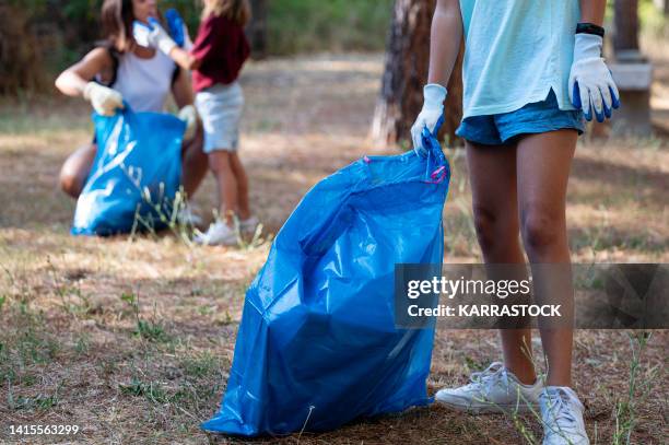 volunteer children collecting garbage in a park. - global citizen together at home stock pictures, royalty-free photos & images