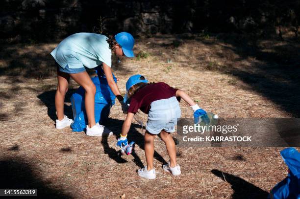 volunteer children collecting garbage in a park. - global citizen together at home stock pictures, royalty-free photos & images