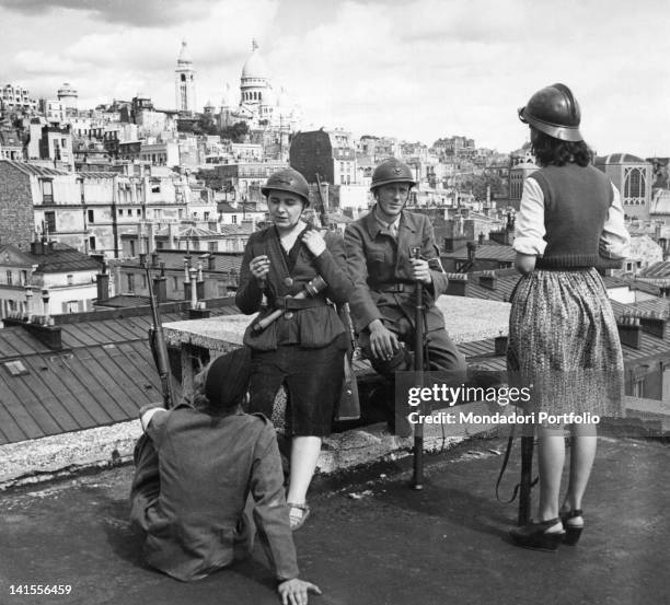 Group of armed partisans keeping watch on the roof of a house. Paris, 28th August 1944