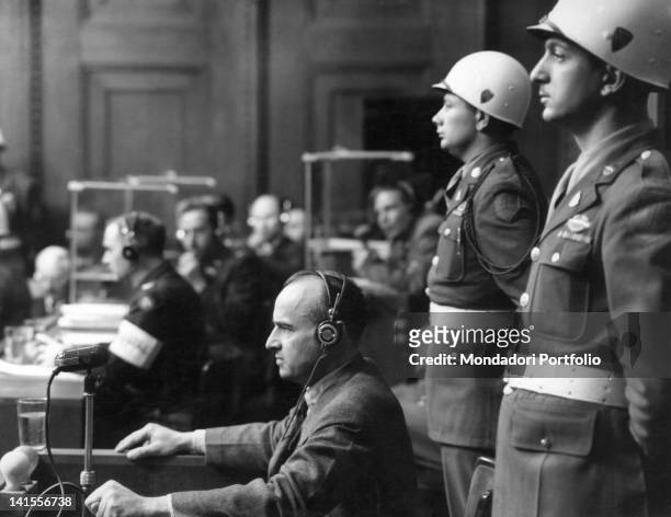 Two soldiers guarding Nazi governor of Poland Hans Frank at the Nuremberg trials. Germany, March 1946