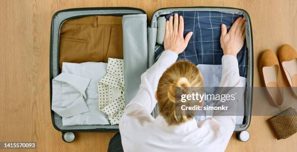 woman packing clothes - suitcase from above imagens e fotografias de stock