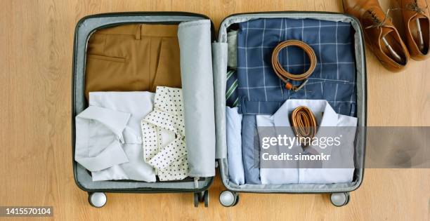 vêtements pliés dans une valise - ceinture par dessus photos et images de collection