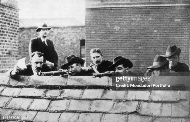 Some Irish rebels lying in wait on a roof getting ready to fire during the Easter Rising. Ireland, 1916