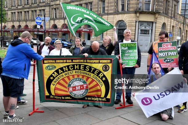 Members of the RMT stand on a picket line outside Manchester Victoria train station during the national rail strike over pay on August 18, 2022 in...