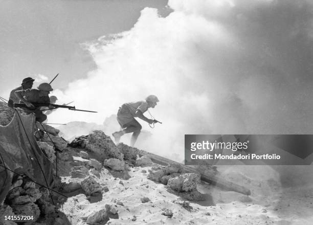 Soldiers and officers of the British infantry attacking among the smoke and the dust on the front of El Alamein.áEl Alamein, 1942
