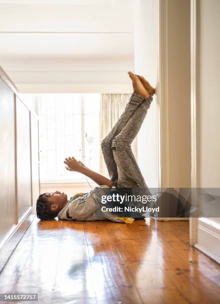 teenage boy busy playing video game on mobile phone at home - feet on table stock pictures, royalty-free photos & images