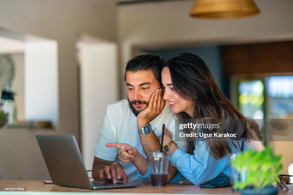 Young couple using laptop in a coffee shop