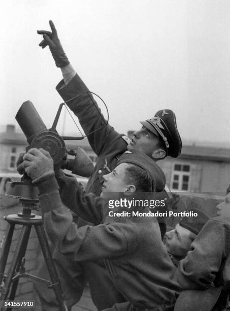 An officer of the Flak illustrates to some men of the Hitlerjugend, the Hitler Youth, how to use instruments for anti-aircraft defence. Germany,...