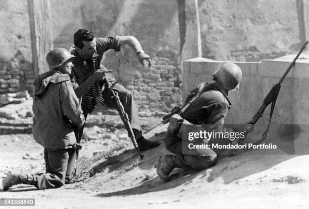 An Italian partisan showing the position of the German soldiers to two U.S. Soldiers of the Fifth Allied Army. Modena, April 1945