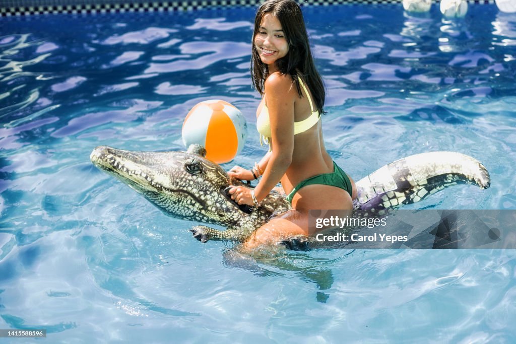 Young woman relaxing at pool in summer.She is having fun with a inflatable ring