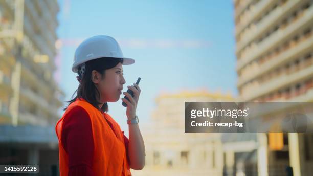 operaia edile che cammina su walkie-talkie - foundations gender equality discussion foto e immagini stock