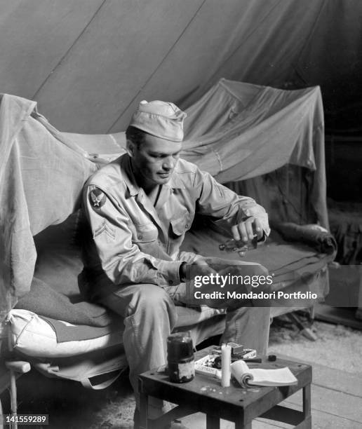 Airman smearing a mosquito-repelling lotion all over himself as protection against malaria in a 12th Air Division base. Italy, July 1944