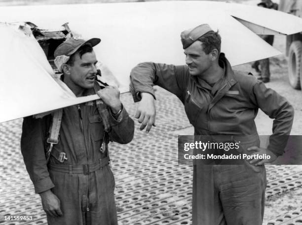 Two airmen checking a seriously damaged B-17 bomber after a raid on Debieczen in Hungary. Italy, 21 September 1944