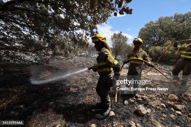 Several INFOAR firefighters pour water on those affected by a fire, in La Muela del Buste, on 18 August, 2022 in La Muela del Buste, Tarazona,...