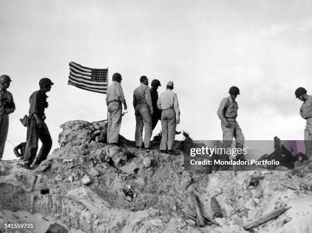 Admiral Chester William Nimitz, his staff officers and some soldiers watching military operations from the island's highest peak. Kwajalein, April...