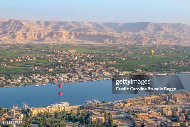 hot air balloons flying over the theban necropolis, river nile, luxor, egypt - nile river stock pictures, royalty-free photos & images