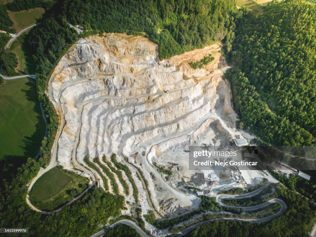 Aerial view of a large quarry, industrial buildings and heavy machinery