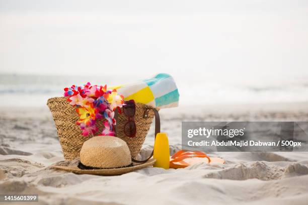 bag with beach accessories kept on sand - strandväska bildbanksfoton och bilder