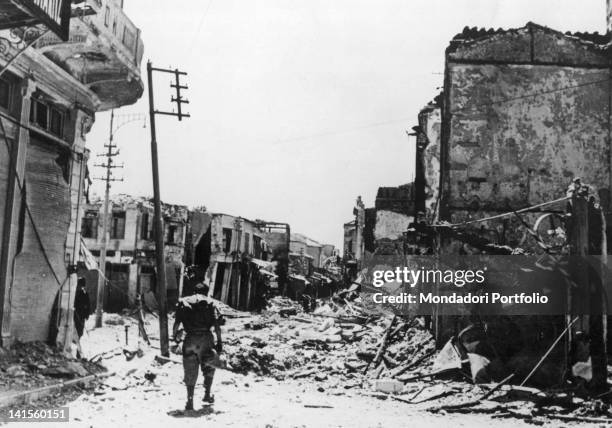 In the River Donets basin, on the Russian front, an Italian soldier walks among the ruins of a devastated village. October 1941