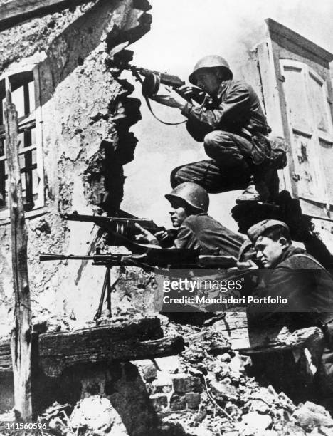 Three Russian soldiers lying in ambush amid the ruins of a building in Stalingrad . Stalingrad, October 1942