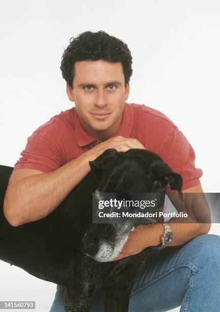 The U.S. Actor Ethan Wayne hugging and curling a big dog. 1991