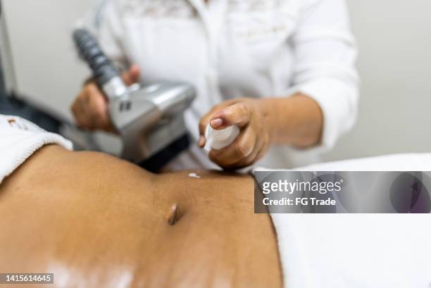 aesthetician applying a cream to do a beauty treatment - belly fat stock pictures, royalty-free photos & images