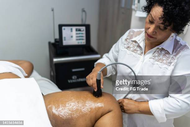 aesthetician doing a beauty treatment on a customer at a spa - cellulit bildbanksfoton och bilder