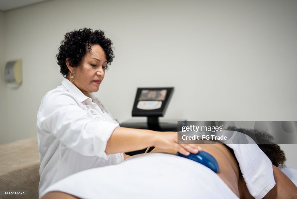 Esteticista haciendo un tratamiento de belleza a un cliente en un spa