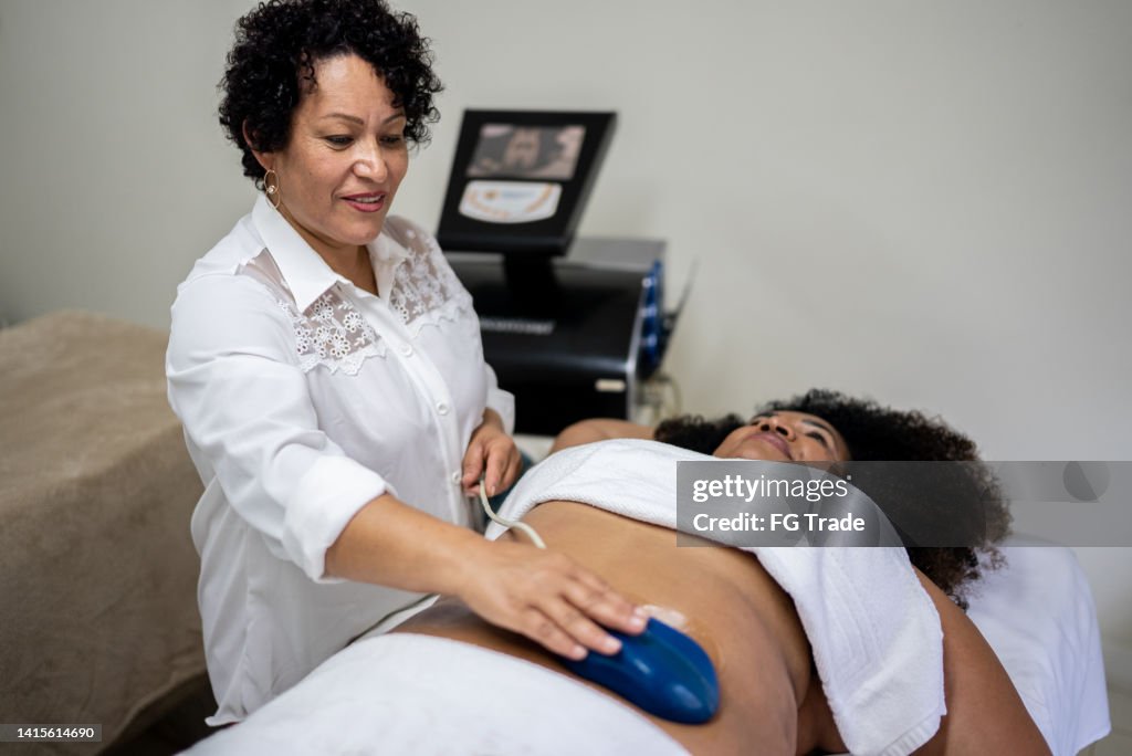 Esteticista haciendo un tratamiento de belleza a un cliente en un spa