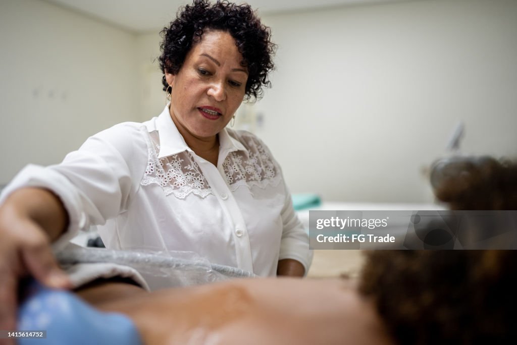 Esteticista haciendo un tratamiento de belleza a un cliente en un spa