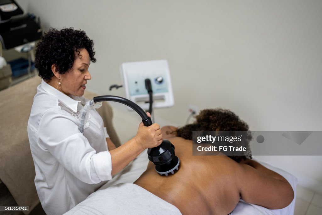 Esteticista haciendo un tratamiento de belleza a un cliente en un spa