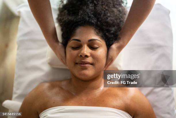 woman receiving massage in a spa - massage table stock pictures, royalty-free photos & images