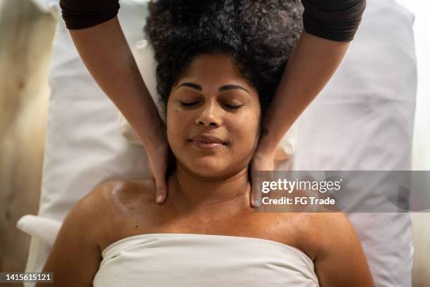 woman receiving massage in a spa - masseren stockfoto's en -beelden