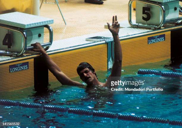 The US swimmer Mark Spitz greets the public, making 'three' with his fingers after having won the 200 metres freestyle final and the third of his...