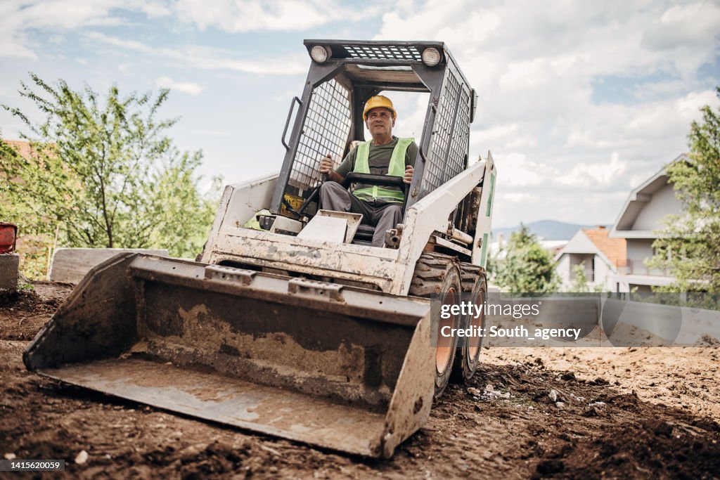 Mature operator in small excavator