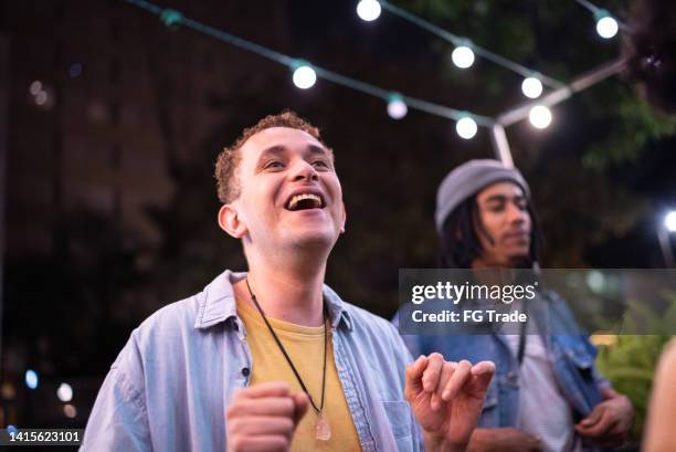 mid adult man having fun with friends in the street at night - alternative lifestyle stock pictures, royalty-free photos & images