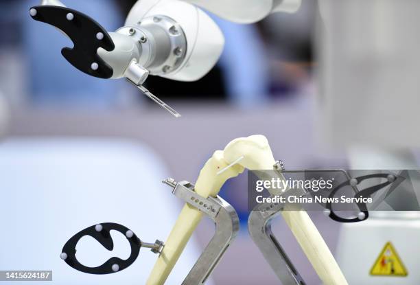 Robotic arm performs a surgery on a joint model during 2022 World Robot Conference at Beijing Etrong International Exhibition & Convention Center on...